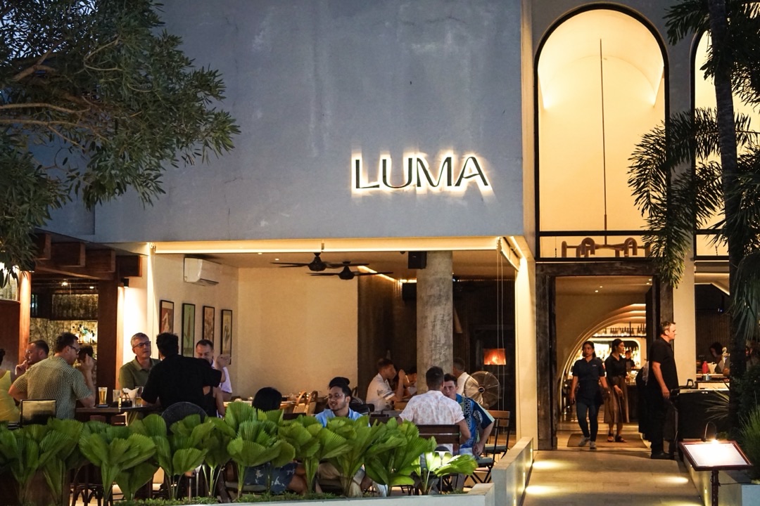 Luma's front terrace at dusk, tables full under the lit sign